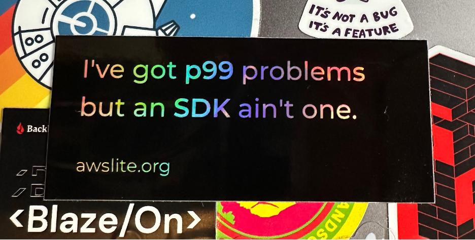 A photo showing an aws-lite promotional sticker that says, I've got p99 problems but an SDK ain't one, as well as a Backblaze promotional sticker that says Blaze/On.